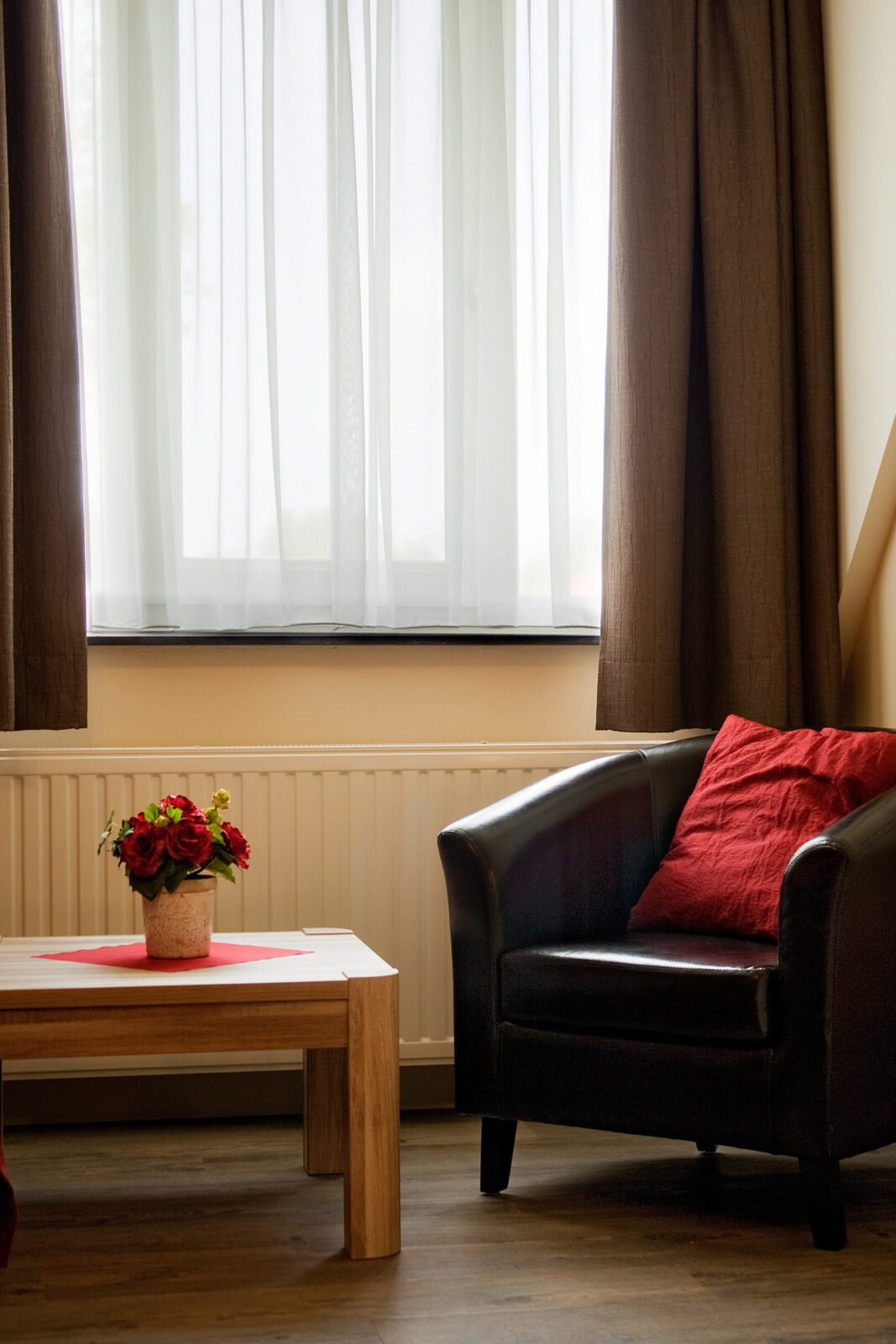 Zithoek met fauteuil bij het raam in de kamer