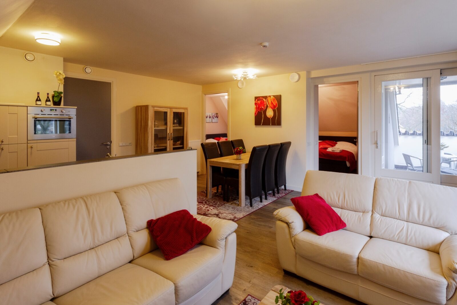 Woonkamer van het appartement met bank en eettafel